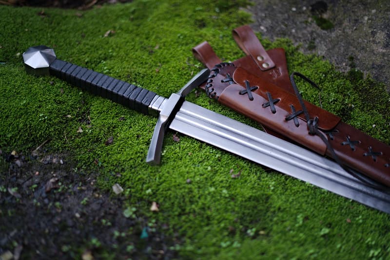 Medieval two-handed striking sword, laced leather scabbard