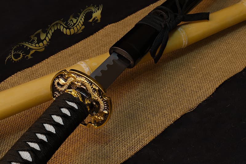 Katana decoration, black saya with screen-printed golden dragon, tsuba dragon and samurai | Lurking in the shadows, I keep watch. Reflecting the moon's rays, my scales gleam like metal plates.
