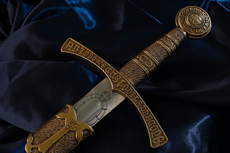 Decorative medieval sword, engraved blade, hilt and pommel with Latin inscriptions, French blue scabbard with fleur-de-lis.