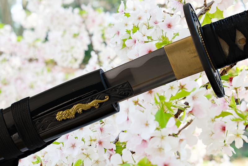 Sharp Wakizashi with wooden scabbard (saya 鞘), supplied with protective fabric cover | As the proverb says: "The most beautiful flower is the cherry blossom, the best man is the warrior" (花は桜木人は武士).