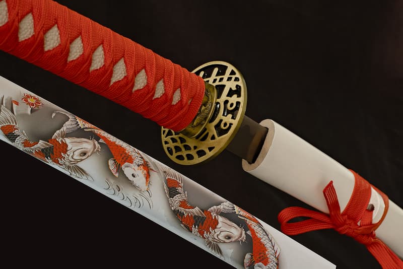 Collection Katana Tsuka-Ito (柄糸) and Sageo (下緒) red, Saya (鞘 scabbard) white with silkscreen depicting Kujaku (孔雀 peacock), variety of Koi carp (鯉 Asian carp) | I symbolize luck, beauty and loyalty. That's why my scabbard (鞘 Saya) is decorated with multiple Kujaku (孔雀), this variety of Koi carp (鯉 Asian carp) that Japanese tradition considers a good luck charm. Its metallic sheen gives it a proud appearance.