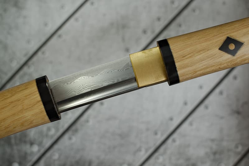 Shirasaya (白鞘 conservation or transport mount), sharp damascened forge blade with scabbard (saya 鞘) and handle (tsuka 柄) in natural lacquered wood, delivered with a protective cloth cover | One on top of the other, slowly, the blacksmith folded the layers that make me up. In the hollow of the forge, I fused with carbon, transformed myself. I learned to use this foreign element imposed on me to transcend it and become another.