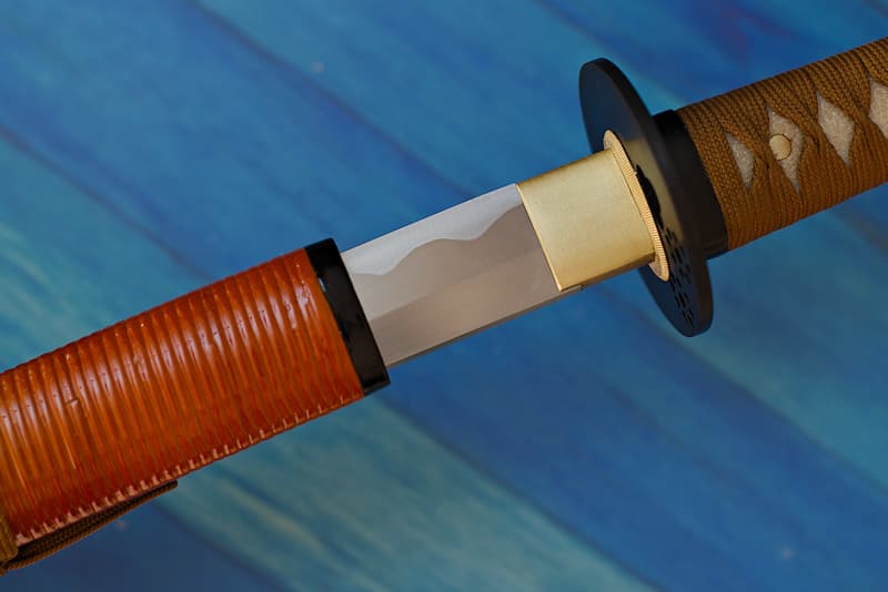 Sharp katana with scabbard (saya 鞘) wood, brown and partial ringed sheath, supplied with protective cloth cover | The first samurai I served lived in Kaga Province (加賀国) in the early XVIIᵗʰ century. He was in the service of the Maeda clan, the real family that ruled Japan during the Tokugawa shogunate period.