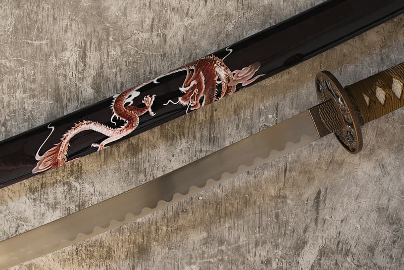 Collectible katana with black saya (鞘) decorated with a screen-printed dragon, tsuba (鍔) dragon, tsuka-ito (柄糸) and sageo (下緒) brown | My saya is decorated with a dragon. But it's not just any dragon. It's the "player" dragon. It's so nicknamed because it appears and disappears as it pleases, driving its victims to madness.
