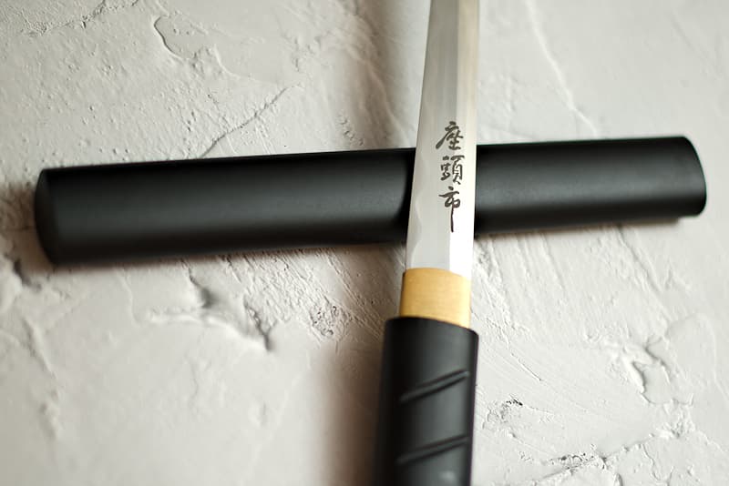 Aiguchi (mount without tsuba) sharpened black, straight blade with engraving (座頭市 Zatōichi), delivered with protective cloth cover | Straight, my blade is mounted unobtrusively, like a sword cane. My black cladding makes me almost invisible, until my master swordsman draws me.