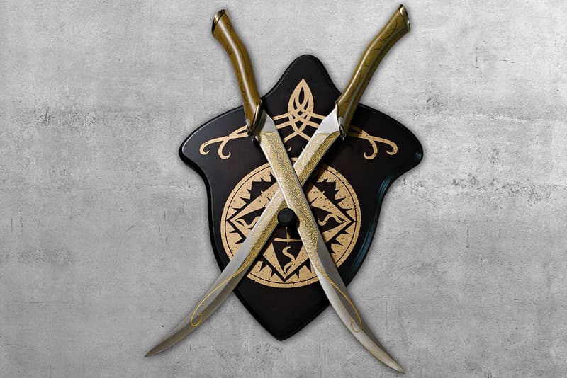 Set of two collector's daggers in cast steel and metal, silk-screened resin, engraved blades, delivered with a wall bracket | J.R.R. Tolkien, author of the saga "The Lord of the Rings", had presented me alone, but the film adaptation opted for me to be accompanied by my twin sister.