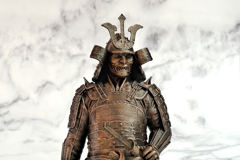 3D-printed collectible statuette, hand-finished, aged bronze look | In my lifetime, I wouldn't have imagined that my bust would be used as a model. My characteristic armor (鎧 Yoroï), is thus reproduced with many details, along with my Kabuto (兜 samurai helmet), my Mempō (面頬 samurai mask)