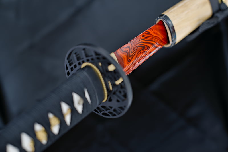 Sharp Katana, blade painted red and black, with natural lacquered wood scabbard (saya 鞘), black sageo (下緒) and tsuka-Ito (柄糸) | Some people search for their purpose all their lives. Others explore, find it and follow their path in harmony.