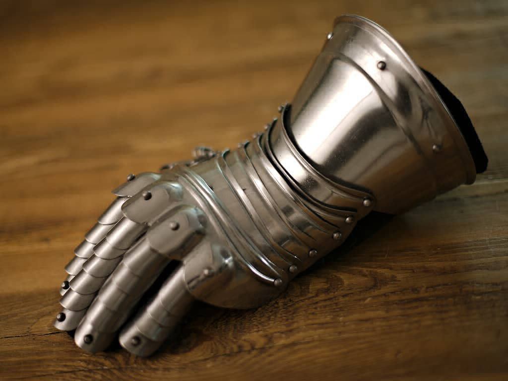 Articulated gauntlet on a medieval wooden table