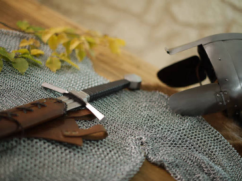 Staging medieval chain mail with helmet and fighting sword