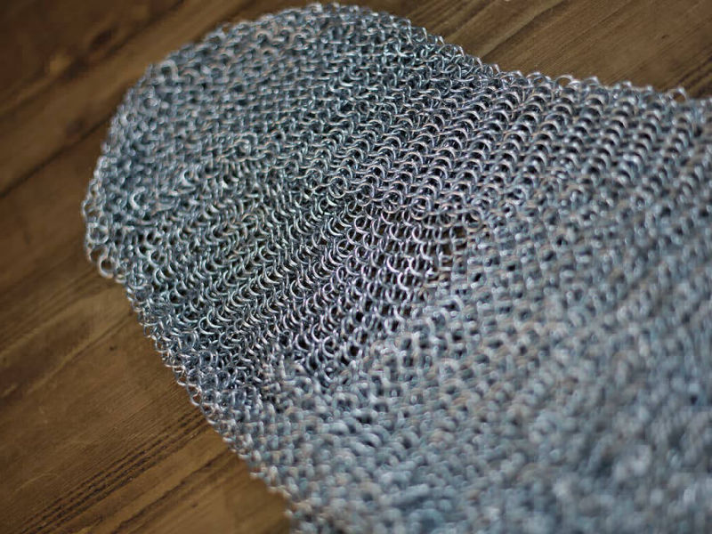 Medieval camail armor on a medieval wooden table Medieval camail armor on a medieval wooden table