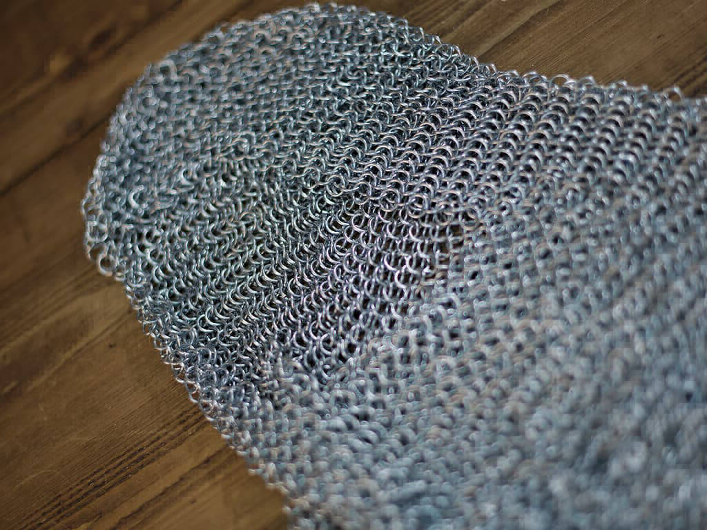 Medieval camail armor on a medieval wooden table Medieval camail armor on a medieval wooden table