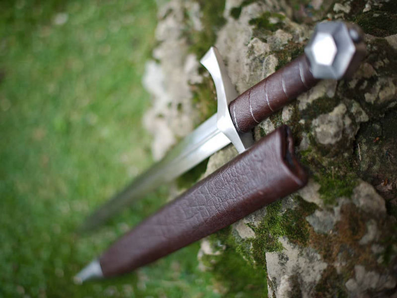 Medieval "Lightbane" combat dagger set on a natural mouse-covered rock