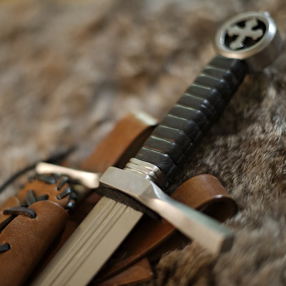Dague médiévale du chevalier croisé (dague de combat, pommeau croix tréflée et fourreau cuir brun lacé, porté oblique)