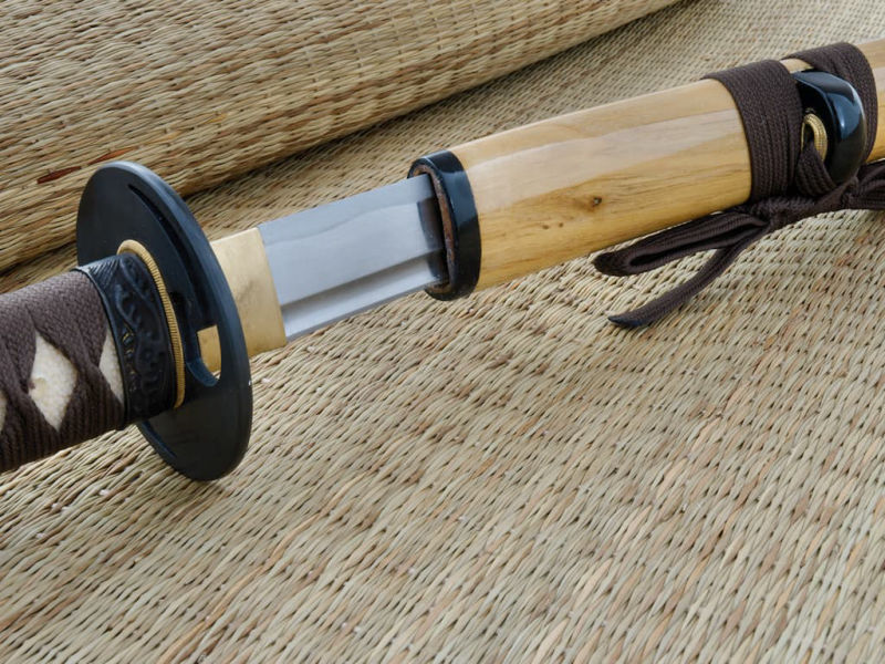 Sharpened katana wood (mù, 木) metal (jīn, 金), set on a straw mat Sharpened katana wood (mù, 木) metal (jīn, 金), set on a straw mat