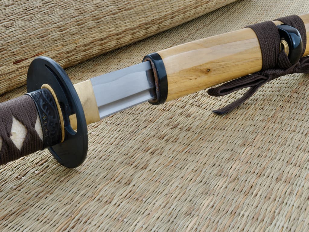 Sharpened katana wood (mù, 木) metal (jīn, 金), set on a straw mat Sharpened katana wood (mù, 木) metal (jīn, 金), set on a straw mat