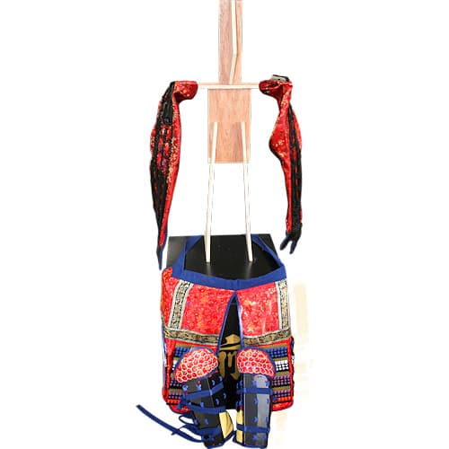 Assembling red samurai armor: fitting sleeves to wooden skeleton Assembling red samurai armor: fitting sleeves to wooden skeleton