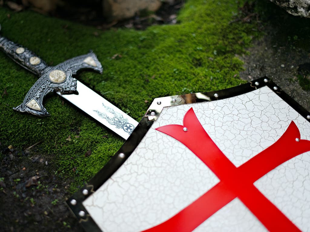 Decorative Templar shield and sword in a natural rock and moss setting Decorative Templar shield and sword in a natural rock and moss setting