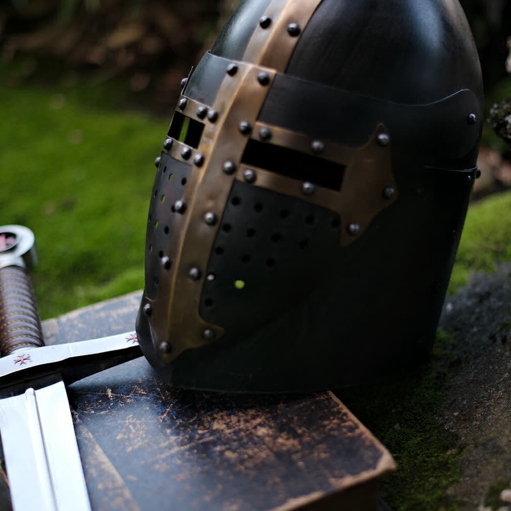 Templar black helmet with golden Templar cross, placed on a sword and an ancient book.