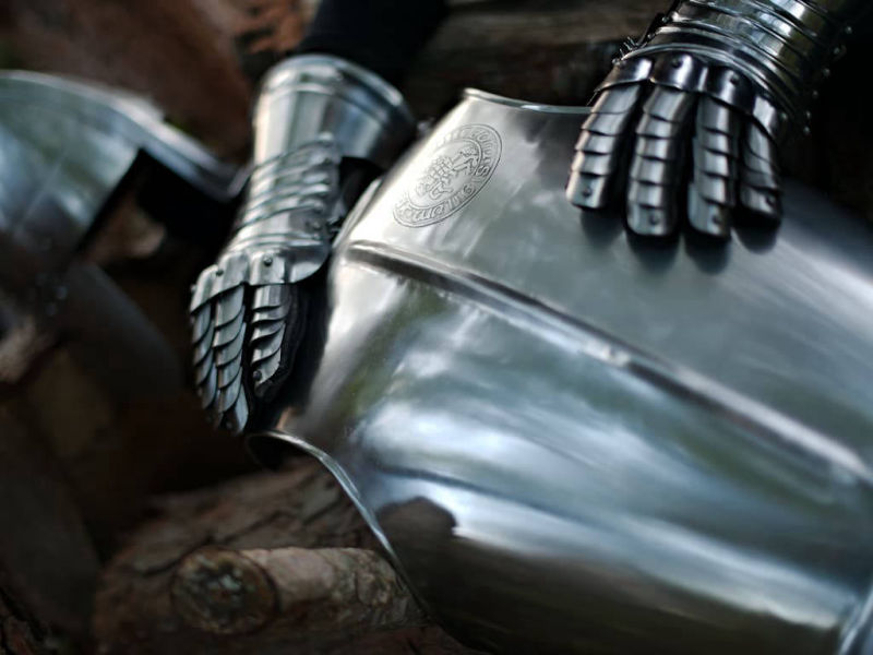 Breastplate with embossed Templar seal, staged with a pair of gauntlets and a medieval helmet Breastplate with embossed Templar seal, staged with a pair of gauntlets and a medieval helmet