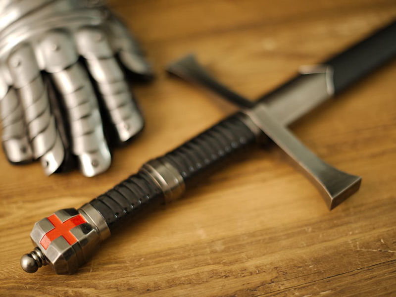 Decorative Templar sword set on a medieval wooden table, with a branch whose branches shelter dewdrops. Templar sword "Return from the Holy Land" #Terressens